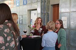 Teilnehmerinnen unterhalten sich und trinken dabei einen Lavendelspritz.