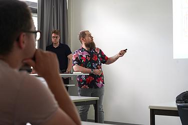 Ein Teilnehmer präsentiert seine Ergebnisse vor der Gruppe und erläutert Inhalte seiner Projektarbeit.