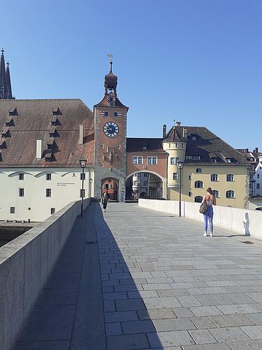 Donau mit Blick auf die Altstadt von Regensburg, im Vordergrund die Wellen, im Hintergrund historische Gebäude