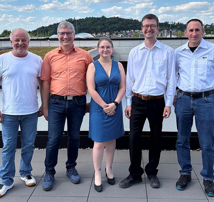 Angehende staatlich geprüfte Techniker der Eckert Akademie Regenstauf präsentieren die Ergebnisse ihrer praxisnahen Projektarbeiten vor einer Präsentationsfläche.