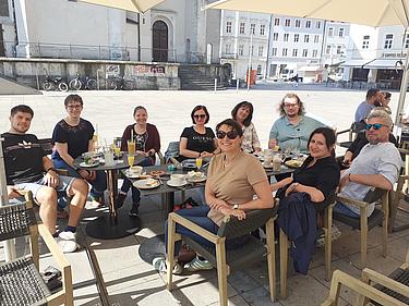 Gruppe von Menschen beim Frühstück im Straßencafé in der Altstadt von Regensburg