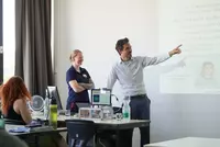 Prof. Dr. Matthias Ehrnsperger und Anna Linhuber präsentieren gemeinsam vor Studierenden und geben Einblicke in Studieninhalte sowie mögliche Anschlusswege nach dem Technikerabschluss.