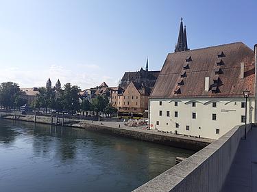 Altstadtpanorama von Regensburg mit Blick auf die Donau, historische Gebäude und den Dom, aufgenommen von der Steinernen Brücke.