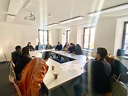 Exkursion Augsburg 03 Teilnehmende eines Integrationskurses der Eckert Schulen sitzen gemeinsam an Tischen und besprechen Aufgaben im Rahmen einer Stadtrallye in Augsburg.