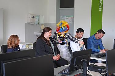 Person in buntem Kostüm sorgt für kreative Stimmung im Seminarraum.