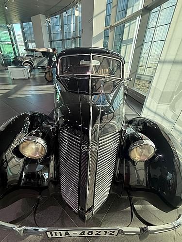 Schwarzer Oldtimer im Audi Museum Ingolstadt, frontal aufgenommen in heller Ausstellungsumgebung mit Glasfassade.