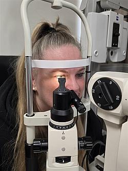 Präzision bei der Augenuntersuchung Nahaufnahme einer Teilnehmerin am Spaltlampenmikroskop während der Untersuchung.