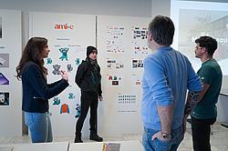 Teilnehmer und Dozenten im Austausch vor einer Markenmatrix mit ausgearbeiteten Design- und Kommunikationsbausteinen.