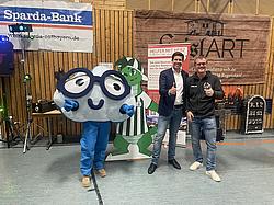 Eckert-Maskottchen EDDI mit zwei Vertretern bei der Benefizveranstaltung in der Mehrzweckhalle Ramspau.