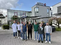 Mehrere Menschen stehen vor einem Gebäude.