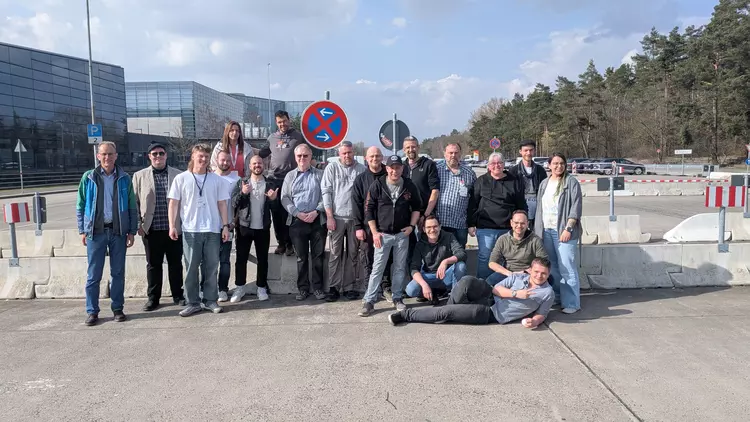Gruppenfoto von Teilnehmenden der Ausbildungsrichtungen EGS und IT mit ihren Dozenten vor dem Messegelände der embedded world 2026 in Nürnberg, aufgenommen im Außenbereich bei sonnigem Wetter.