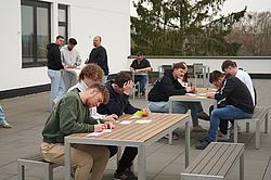 Gruppenarbeit im Freien: Teilnehmende bearbeiten Aufgaben und entwickeln gemeinsam Lösungsansätze.