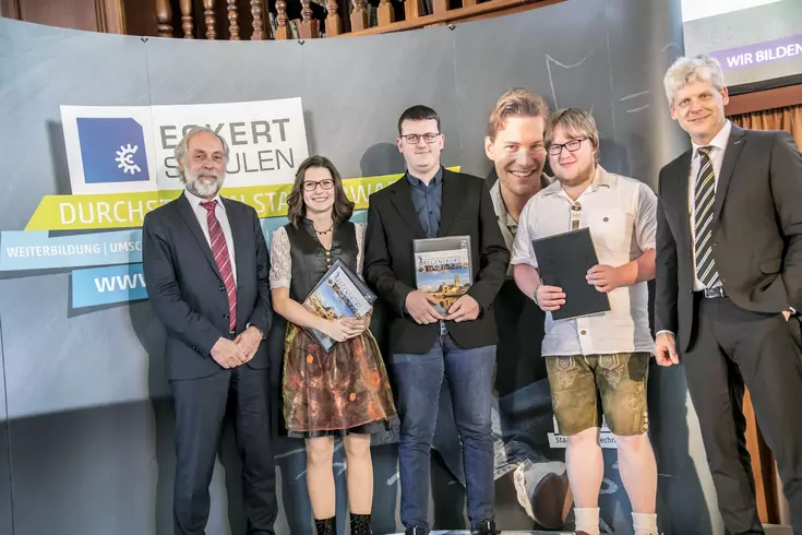 Drei Absolventen erhielten diesmal nicht nur den Meisterpreis der Bayerischen Staatsregierung, sondern auch den Eckert-Buchpreis für eine Abschlussnote von 1,5 oder besser. Es gratulieren Gottfried Steger (stellvertretender Vorstandsvorsitzender der Ecker Drei Absolventen erhielten diesmal nicht nur den Meisterpreis der Bayerischen Staatsregierung, sondern auch den Eckert-Buchpreis für eine Abschlussnote von 1,5 oder besser. Es gratulieren Gottfried Steger (stellvertretender Vorstandsvorsitzender der Eckert Schulen) und Markus Johannes Zimmermann (Geschäftsführer der Dr. Eckert Akademie)