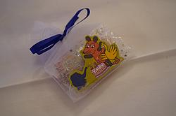 Geschenkbeutel aus Organza mit blauer Schleife, dekoriert mit einem Aufkleber der „Sendung mit der Maus“, Maus, Ente und Elefant vor einer Geburtstagstorte.
