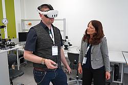 Zwei Personen probieren mit der VR-Brille herum.