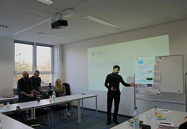 Teilnehmer präsentiert eine Jahresplanung am Flipchart im Rahmen des Projekts ChancenWerk an den Eckert Schulen, andere Teilnehmende hören zu.