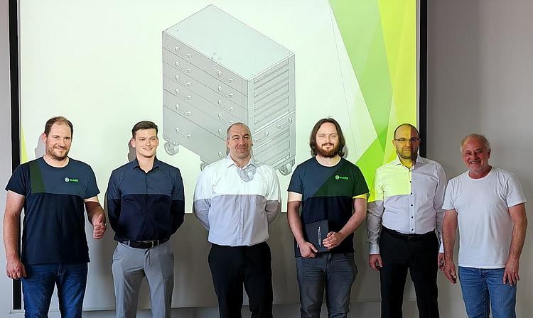 Angehende staatlich geprüfte Techniker der Eckert Akademie Regenstauf präsentieren die Ergebnisse ihrer praxisnahen Projektarbeiten vor einer Präsentationsfläche.