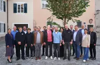 Gruppenfoto der Absolventinnen und Absolventen sowie Beteiligten des Industriemeister-Lehrgangs Aufbereitungs- und Verfahrenstechnik auf einem historischen Platz.