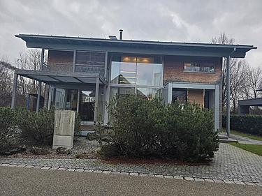Musterhaus mit Holz- und Glasfassade im Bauzentrum Poing als Beispiel für nachhaltige und moderne Bauweisen.