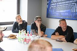 Drei Männer hören aufmerksam dem Vortrag des Dozenten zu.