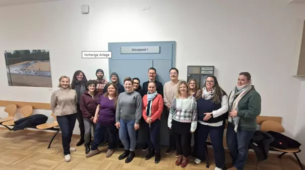 Gruppenfoto der Klassen GK1 und GK3 im Gebäude des Arbeitsgerichts Regensburg vor dem Sitzungssaal während einer Exkursion.