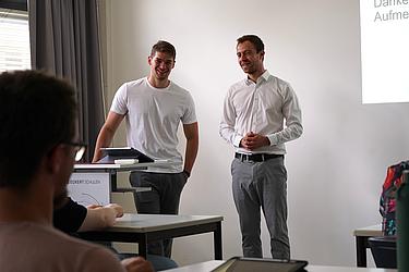 Zwei Teilnehmende präsentieren ihre Ergebnisse vor der Gruppe im Seminarraum der Eckert Schulen.