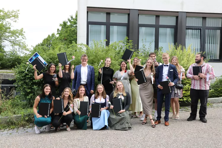 Abschlussfeier Medizin 07 2025 Gruppe von Absolventinnen und Absolventen der Eckert Schulen mit Urkunden und Blumen beim Absolventenkongress 2025