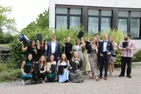 Abschlussfeier Medizin 07 2025 Gruppe von Absolventinnen und Absolventen der Eckert Schulen mit Urkunden und Blumen beim Absolventenkongress 2025
