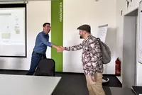 Mitarbeiter des Berufsförderungswerks Eckert im Gespräch mit einem Forscher der Technischen Universität Dortmund während eines Interviews zum Projekt „Digi-Reha“.