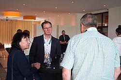 Mehrere Personen im Gespräch bei einem Stehtisch während einer Veranstaltung.