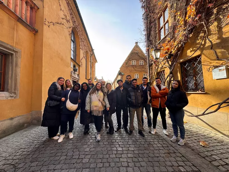 Exkursion Augsburg 02 Teilnehmende eines allgemeinen Integrationskurses der Eckert Schulen stehen gemeinsam in der Fuggerei in Augsburg während einer Stadtrallye.