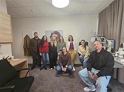 Gruppenbild im Kompetenzzentrum Gruppe von Teilnehmenden der Augenoptik steht gemeinsam in einem Untersuchungsraum im Kompetenzzentrum.
