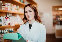Frau steht in einer Apotheke.