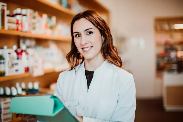 Frau steht in einer Apotheke.