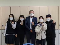 Stephan Koller (Prokurist, Kaufmännischer Leiter, Regionales Bildungszentrum Eckert) beim persönlichen Kennenlernen mit den Teilnehmerinnen der internationalen Kooperation. Das Handzeichen bedeutet „Korean Heart“. (Foto: Eckert Schulen)