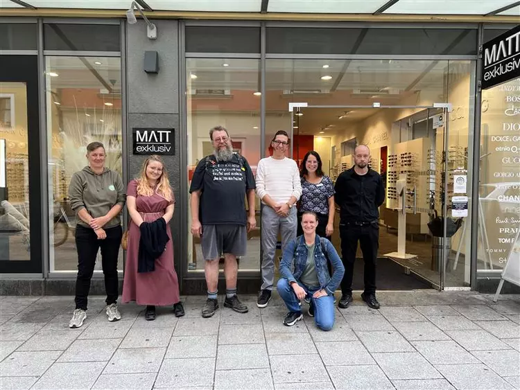 Gruppe der Teilnehmenden steht vor dem Eingang des Optikgeschäfts MATT exklusiv in Regensburg.
