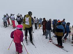 Teilnehmende der Rotary Skimeisterschaft 2025 auf der Piste Mehrere Teilnehmende der Rotary Skimeisterschaft stehen startbereit auf der Piste. Unter den Teilnehmenden befinden sich sowohl Erwachsene als auch Kinder. Das Wetter ist auffällig neblig.