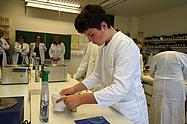Schüler führt selbstständig ein Experiment mit Laborgeräten durch.
