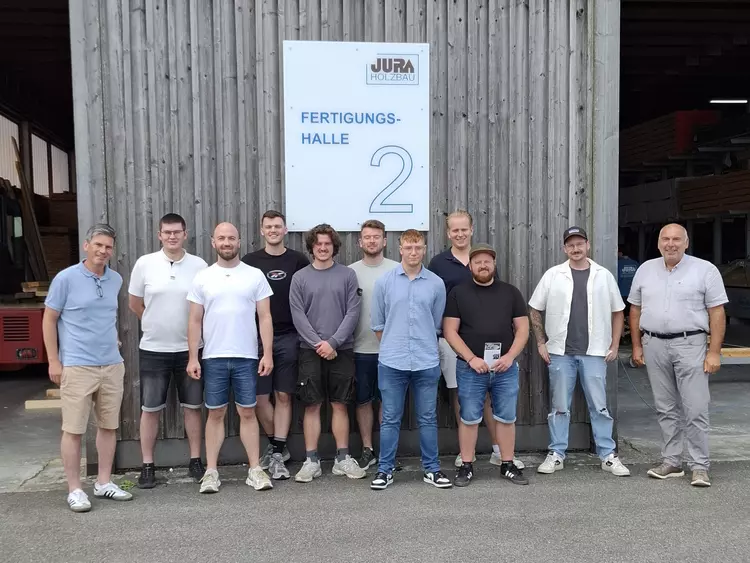 Studierende des zweiten Semesters der Holztechnikerweiterbildung erhalten bei JURA-Holzbau Einblicke in die Fertigung moderner Holzhäuser.