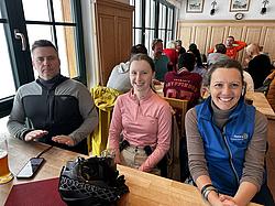 Geselliges Beisammensein in der Hütte Mehrere Teilnehmende der Rotary Skimeisterschaft Indoor in der Hütte sitzen gesellig zusammen.