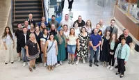 Große Gruppe von Teilnehmenden und Begleitpersonen steht für ein Gruppenfoto im Foyer des Landratsamtes Regensburg zusammen.