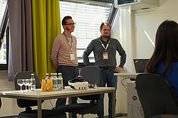 Dozent und Rehabilitand hören dem Vortrag zu,