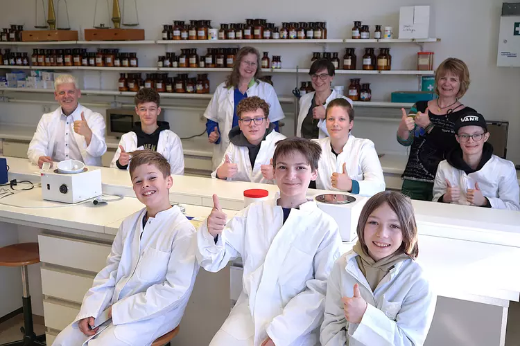 Teilnehmende des Boys Days mit Betreuer und Schulleiter im PTA Labor im weißen Kittel.