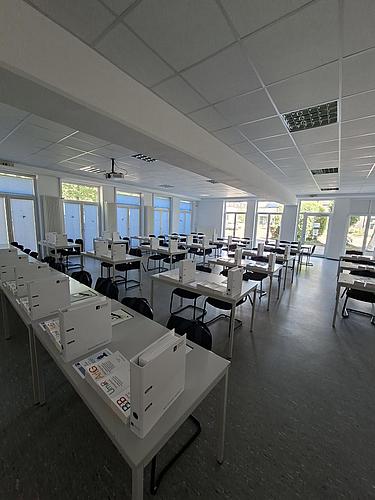 Klassenzimmer mit Unterrichtsmaterialien auf den Tischen.
