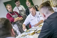 Spitzenkoch Tobias Bätz bei der Manöverkritik der entstandenen Menüs