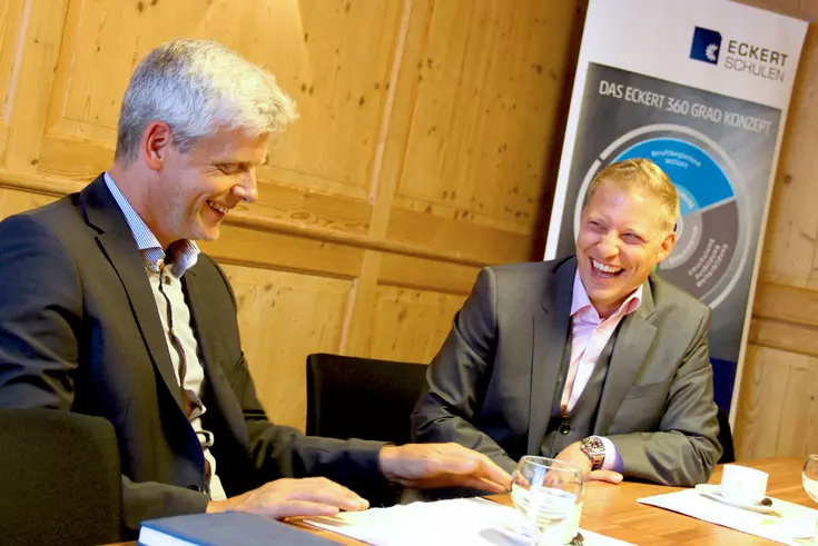 Lockere Stimmung beim Vertragsabschluss: Franz Zachler (Personallleiter bei SMP) und Markus Johannes Zimmermann (Geschäftsführer der Dr. Eckert Akademie) freuen sich auf die künftige Zusammenarbeit.
