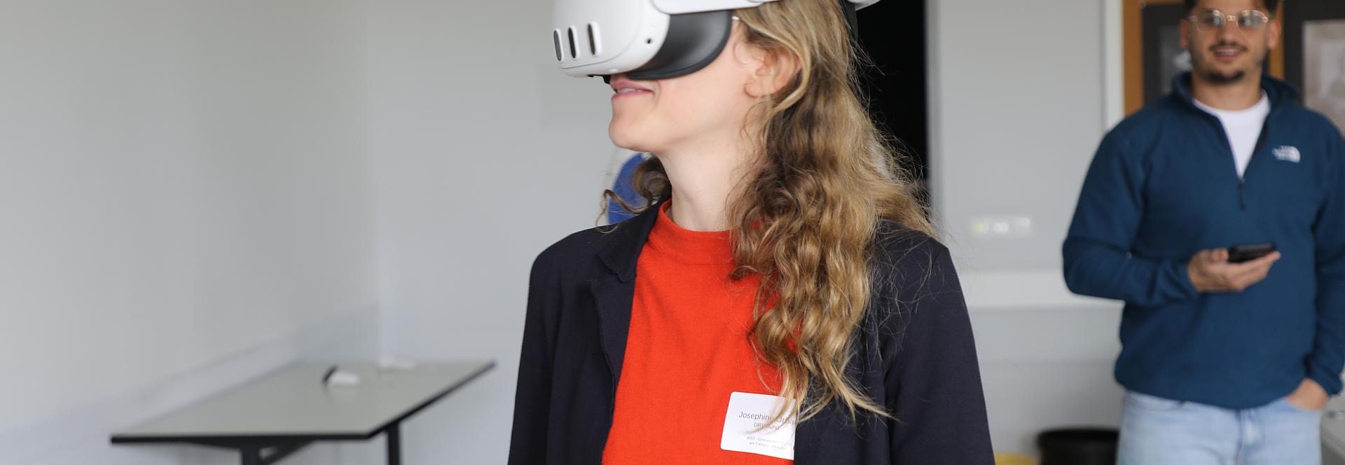 Eine Teilnehmerin der Reha-Fachtagung testet mithilfe einer Virtual-Reality-Brille digitale Lern- und Trainingsanwendungen. Neue Technologien wie VR eröffnen in der Rehabilitation innovative Wege für praxisnahe Übungen und anschauliche Schulungserlebnisse.