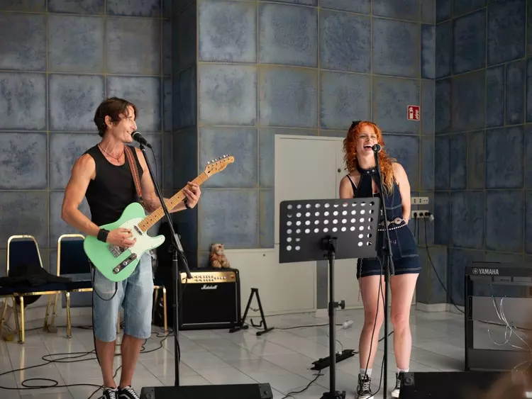 Schulband, BFW Eckert, Musikveranstaltung, Musikergruppe, Publikum, Applaus, musikalisches Engagement, Bandmitglieder, Gemeinschaft, Musikprojekt