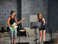 Schulband, BFW Eckert, Musikveranstaltung, Musikergruppe, Publikum, Applaus, musikalisches Engagement, Bandmitglieder, Gemeinschaft, Musikprojekt