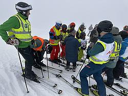 Mehrere Teilnehmende der Rotary Skimeisterschaft stehen startbereit auf der Piste. Unter den Teilnehmenden befinden sich sowohl Erwachsene als auch Kinder. Das Wetter ist auffällig neblig. Mehrere Teilnehmende der Rotary Skimeisterschaft stehen startbereit auf der Piste. Unter den Teilnehmenden befinden sich sowohl Erwachsene als auch Kinder. Das Wetter ist auffällig neblig.